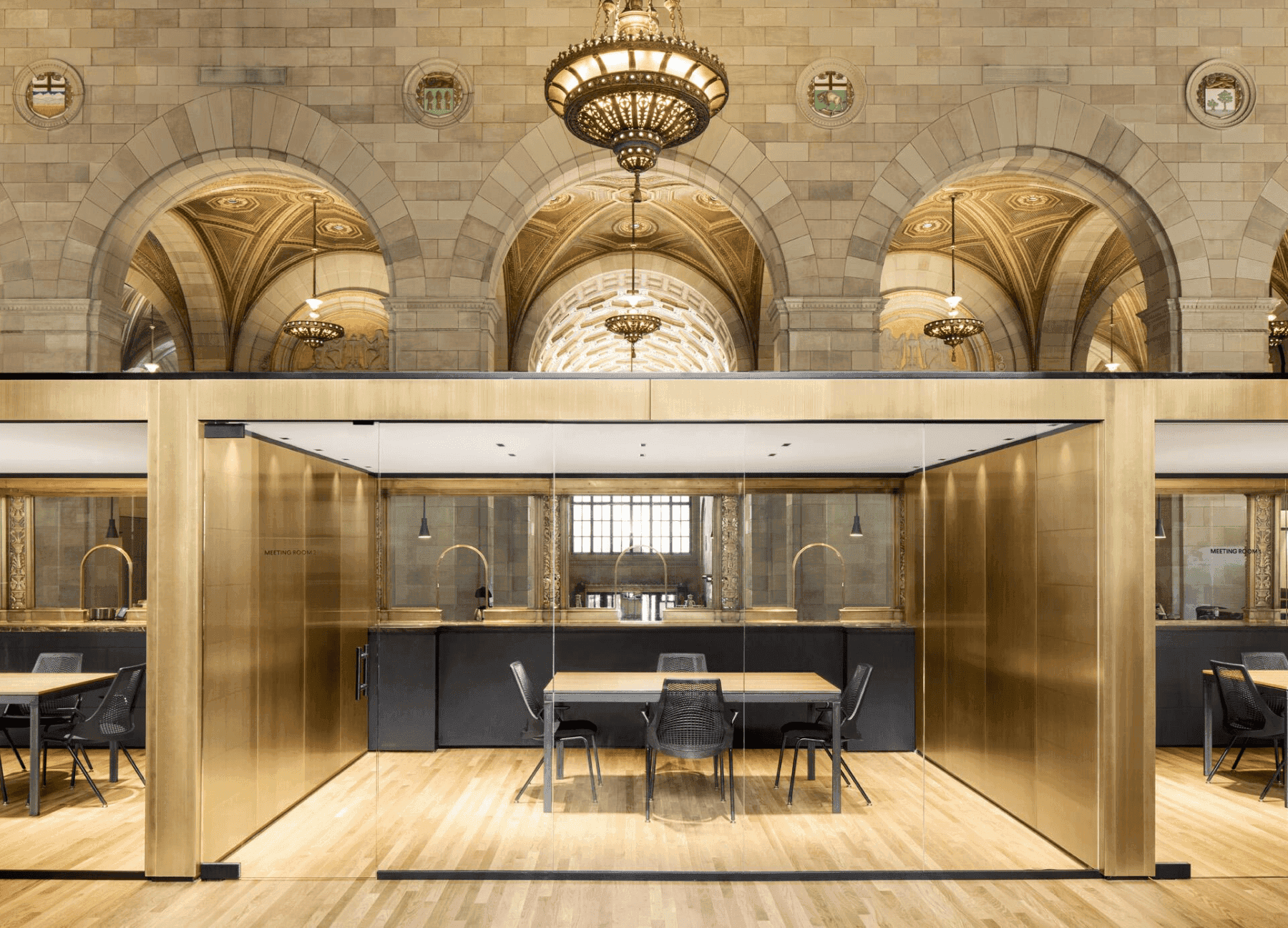 Spacious coworking area in a historic building with high arched windows and people working at tables