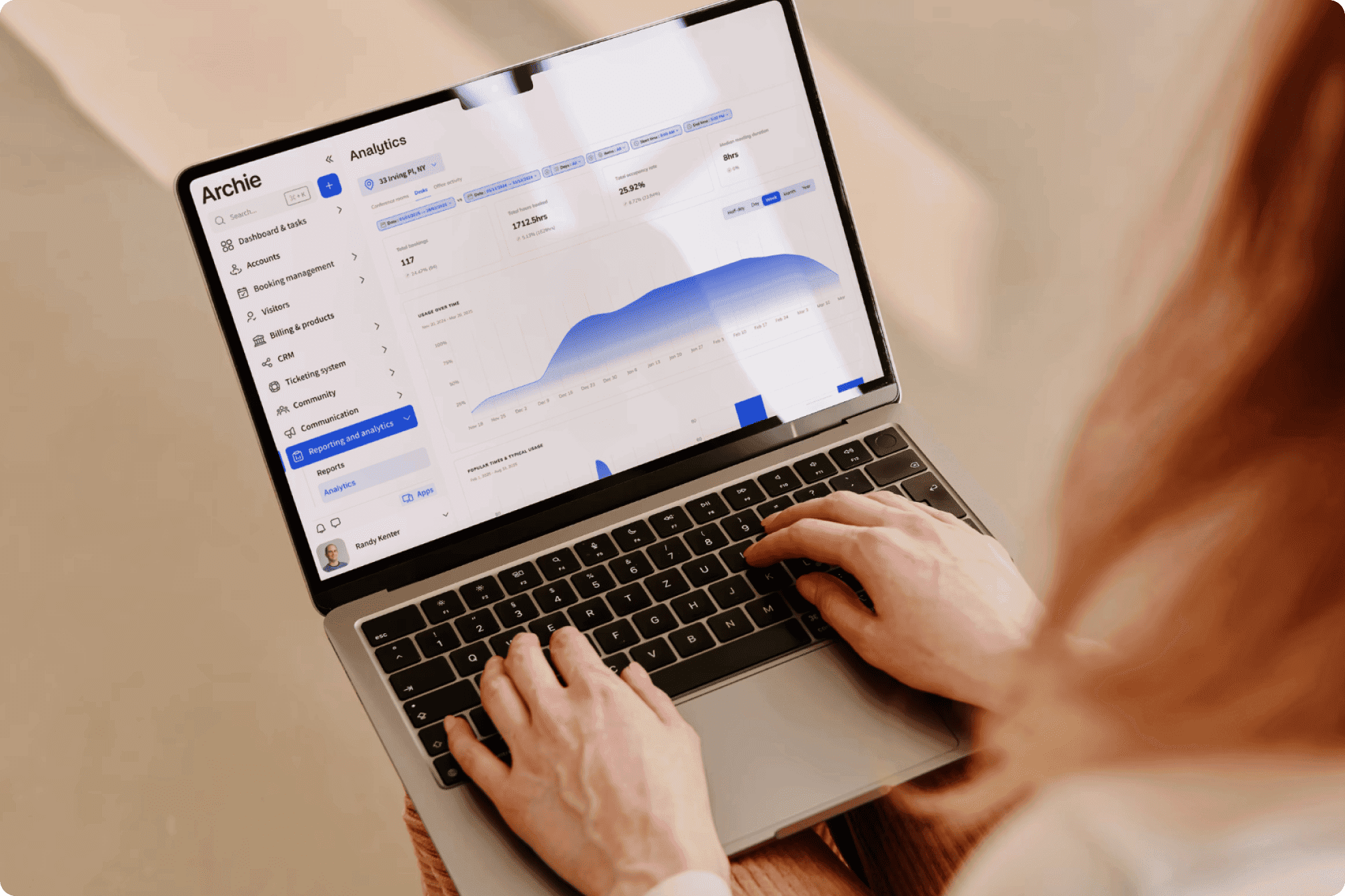 Person using a laptop to view Archie app analytics, including booking and usage trends.