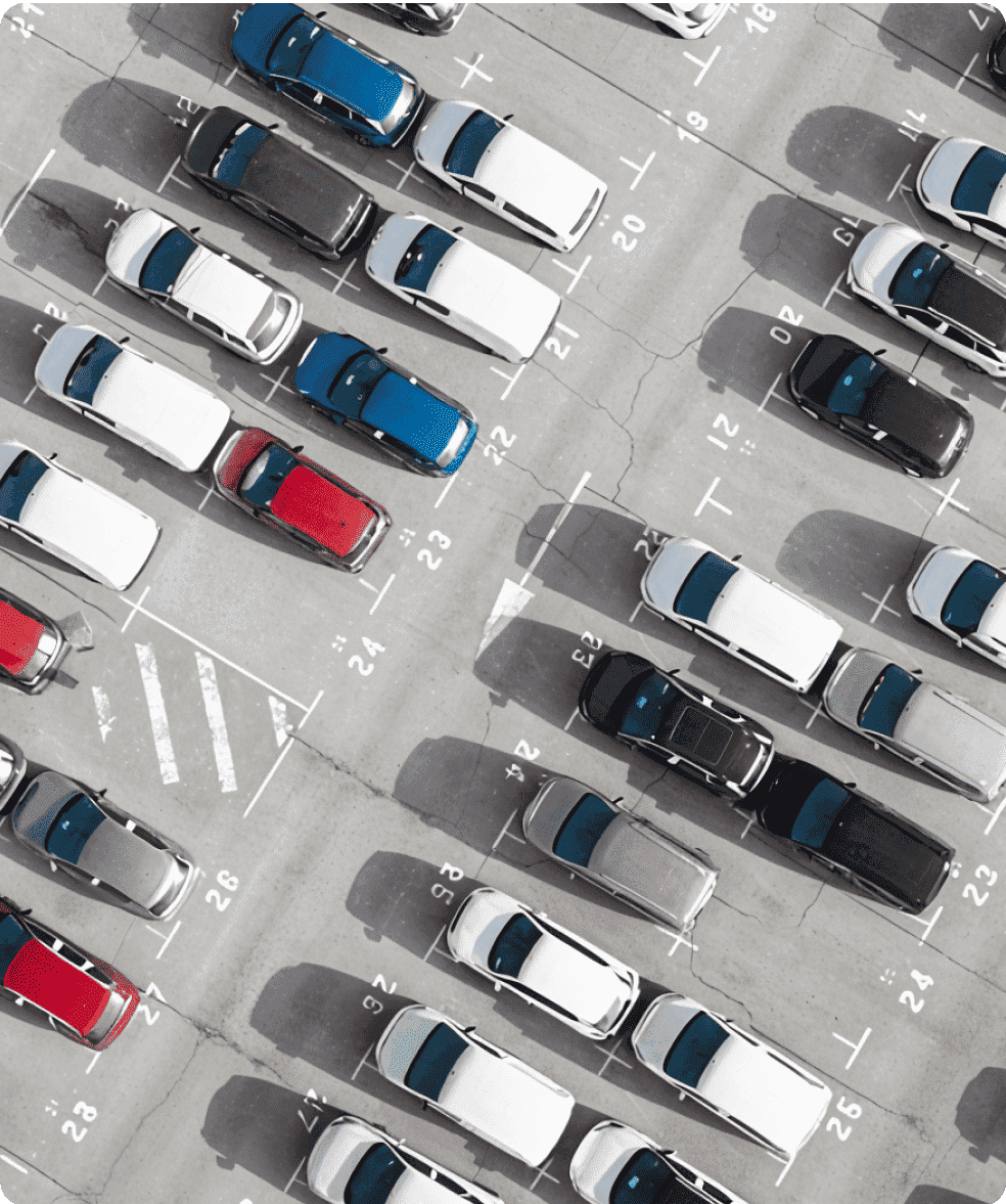 Aerial view of a parking lot with multiple cars parked in designated spaces.