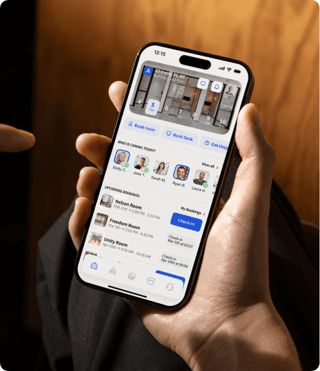 A hand holding a smartphone displaying a booking app for conference rooms in New York City, showing available rooms and booking options.